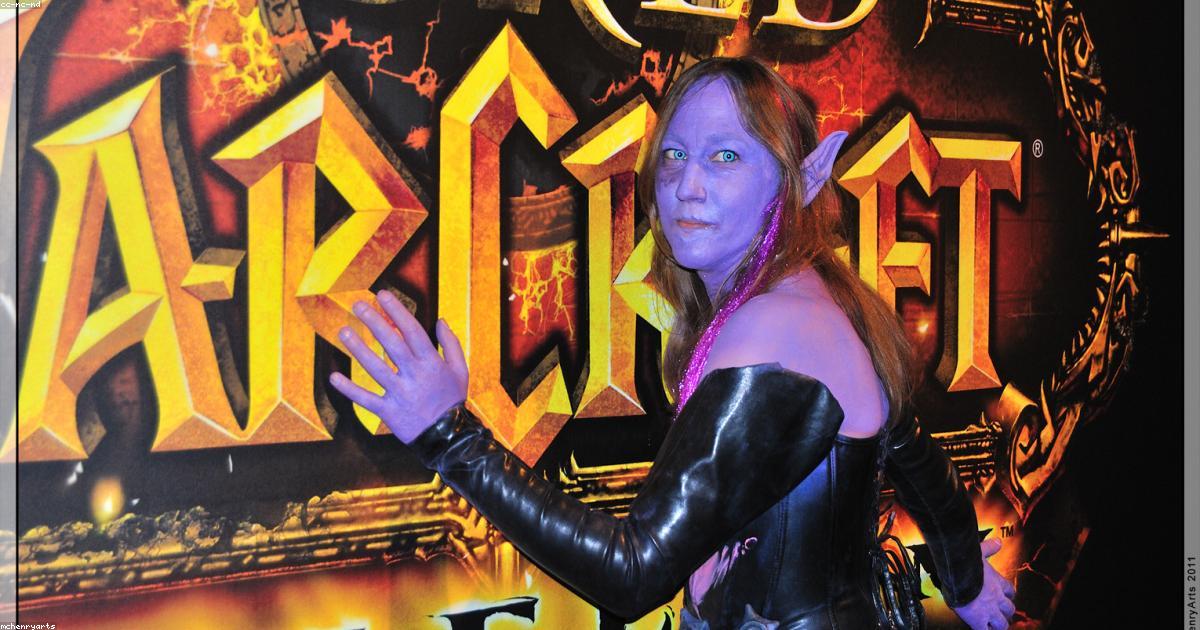 Trade fair exhibition hall with rows of exhibitor booths and visitors